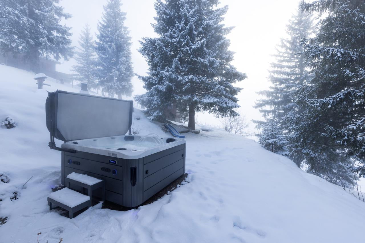 Whirlpool im Schnee mit Bergblick – KURORA® Outdoor Wellnessanlage in winterlicher Umgebung